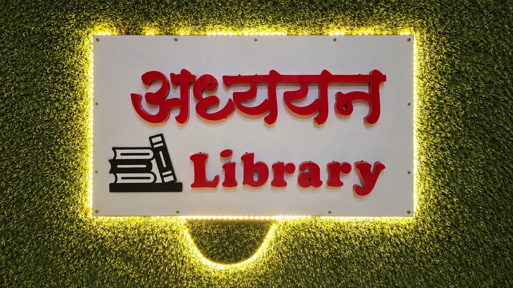Illuminated Adhyayan Library sign at the Padav centre